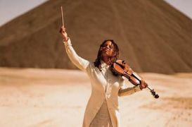 Regina Carter with violin near pyramid
